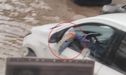Otomobiline dolan suyu bardakla tahliye etmeye çalıştı
